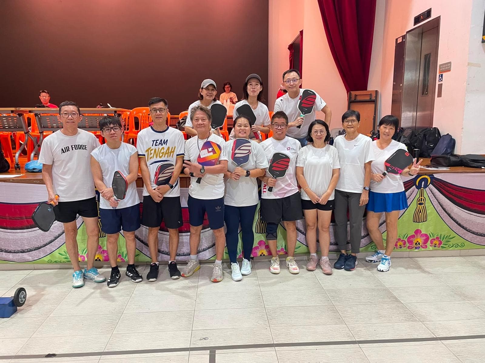 A group of players in white team shirts pose together after their matches.